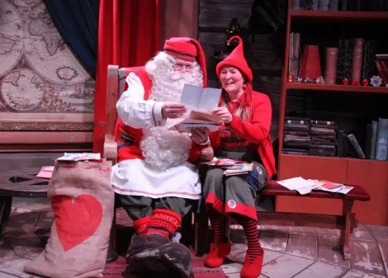 Santa Clause and elf named Rita Matila are reading the letters sent by Chinese children. (Photo by Guan Kejiang from People’s Daily)