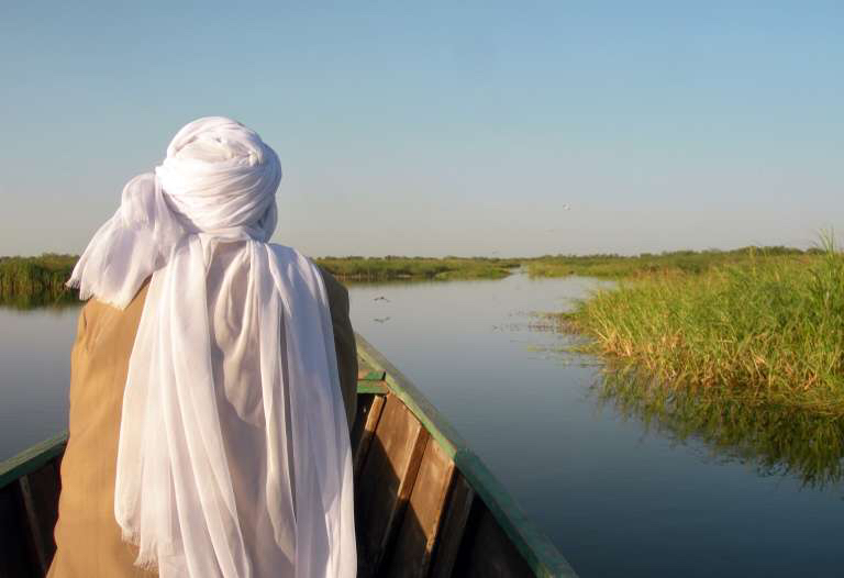 Un vendeur de gas sillonne le lac Tchad à bord de sa pirogue. CRÉDITS : AFP