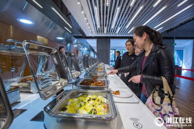 Faculty of Zhejiang University are selecting food in the cafeteria. Sensors installed can calculate weight and calories of the food. (Photo from zjol.com.cn)