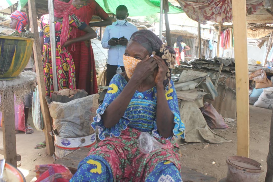 Une femme porte un masque qui lui a été offert, dans un marché de N'Djamena. © Ben Kadabio/Alwihda Info