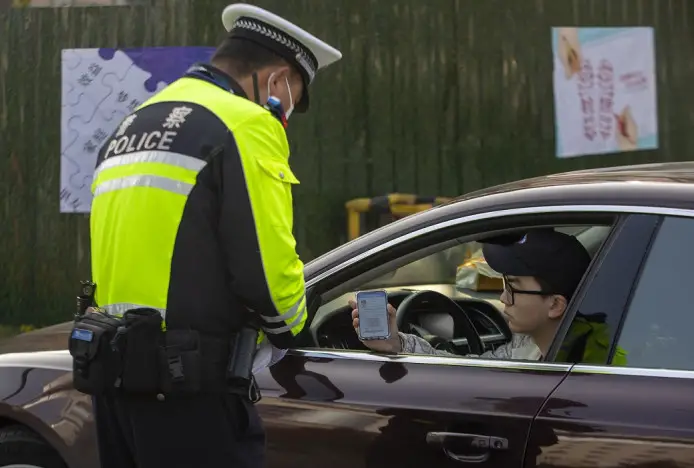 A man shows his digital driver's license to a traffic police officer in Taizhou, east China's Jiangsu province, December, 2021. (Photo by Tang Dehong/People's Daily Online)