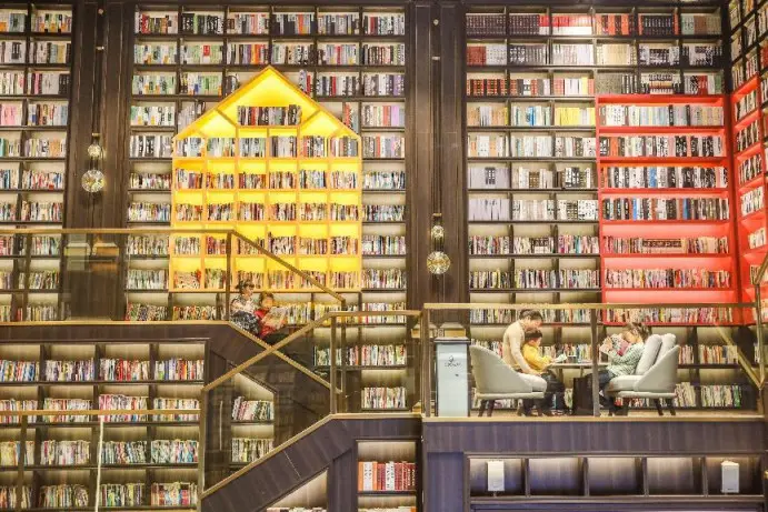 Children read books with parents in a library of a residential complex in Lanshan county, Yongzhou, central China's Hunan province, Jan. 30, 2023. (Photo by Peng Hua/People's Daily)