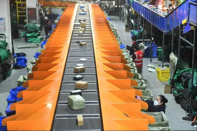 Workers work along an automated sorting line at an express delivery industrial park in Fuyang, east China's Anhui province. (Photo by Wang Biao/People's Daily Online)