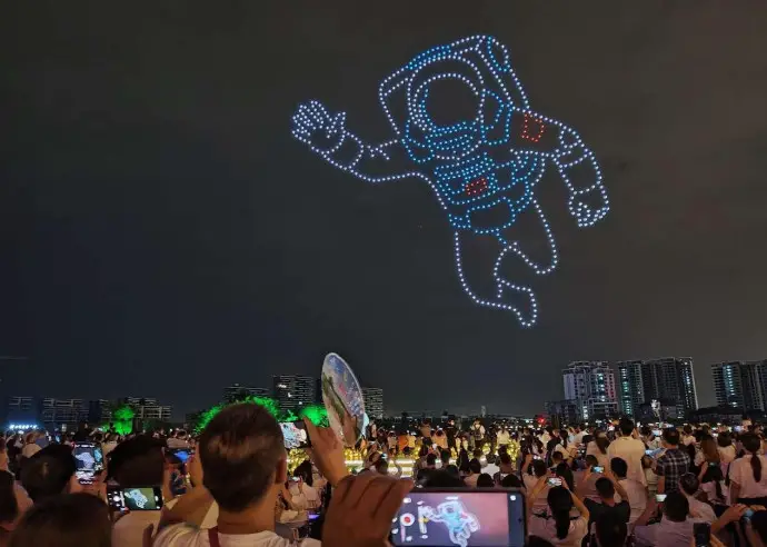 People watch a drone light show in Mianyang city, southwest China's Sichuan province. (Photo by Chen Dongdong/People's Daily Online)