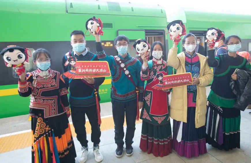 Students from Xide County who used to take the "slow train" for school pose for a group photo in front of D843 "Fuxing" bullet train at Xichang West Railway station in Xichang, Liangshan Yi Autonomous Prefecture, southwest China's Sichuan Province, Jan. 10, 2022.(Xinhua/Jiang Hongjing)