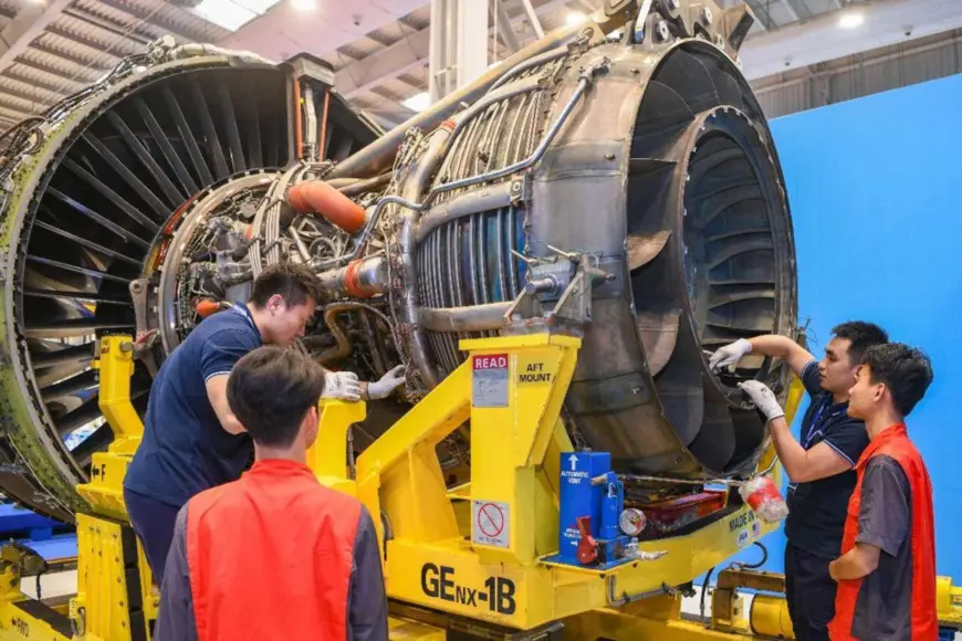 Staff members inspect an engine to be delivered in a maintenance workshop of the Haikou airport comprehensive bonded zone in south China's Hainan province. (Photo by Su Bikun/People's Daily Online)