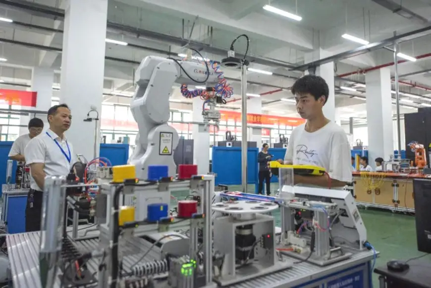Students at Wuhu Machine Engineering School, east China's Anhui province join an industrial robot operation competition. (Photo by Xiao Benxiang/People's Daily Online)