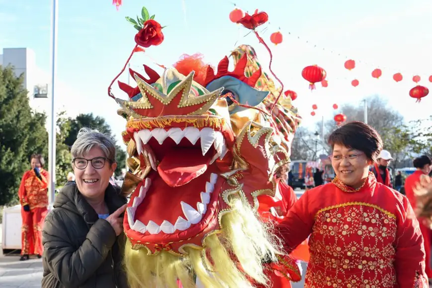 A resident poses for a photo with a lion dancer during an event to celebrate the Chinese New Year in Madrid, Spain, Jan. 20, 2023. A variety of activities were held in Spanish cities to celebrate the Chinese New Year. (Photo by Gustavo Valiente/Xinhua)