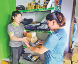 Seytnisa Mamat (right) picks up parcels at a courier station. (Photo provided by the postal administration of Kashgar, Xinjiang Uygur autonomous region)