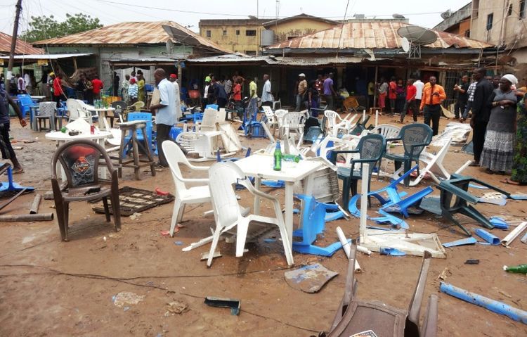 Des gens observent le site d'un précédent attentat à Sabon Gari, près de Kano (nord-est du Nigeria), le 30 juillet 2013 (Photo Aminu Abubakar. AFP)