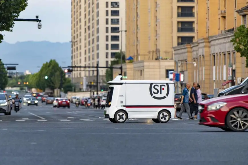 An intelligent autonomous delivery vehicle runs on a road in the urban area of Jinhua city, east China's Zhejiang province. (Photo by Hu Xiaofei/People's Daily Online)