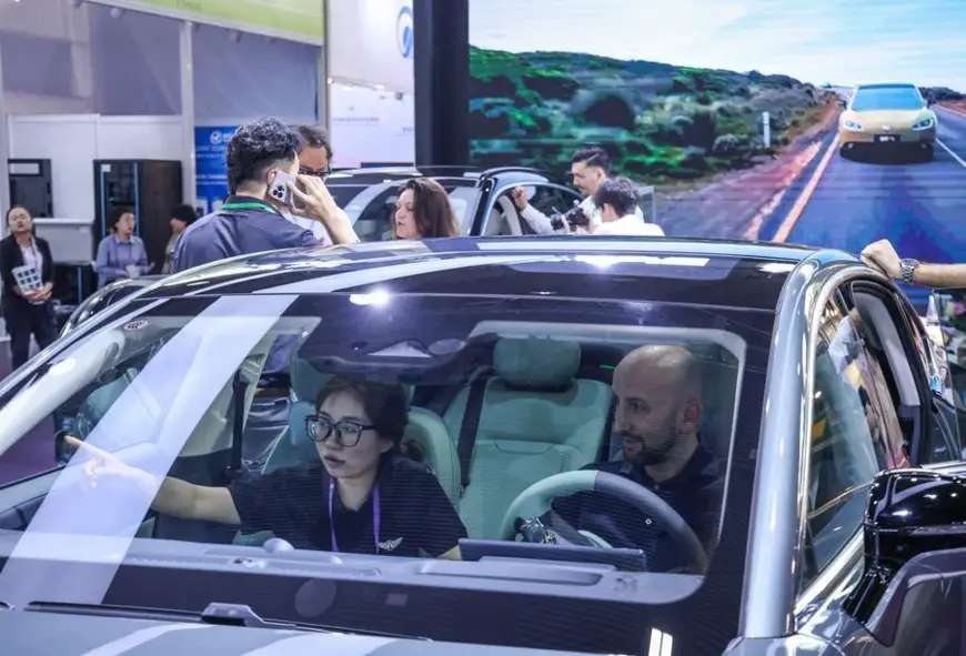 A purchaser learns about an electric vehicle during the 135th session of the China Import and Export Fair in Guangzhou, south China's Guangdong Province, April 15, 2024. (Xinhua/Liu Dawei)