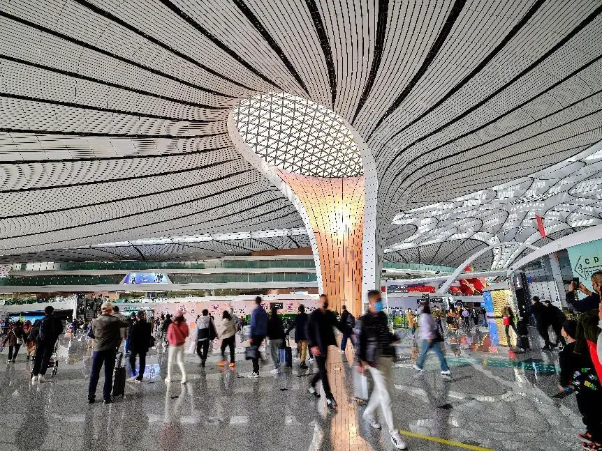 Passengers walk toward departure gates in the domestic departure hall of Beijing Daxing International Airport. (Photo by Shi Jiamin/People's Daily Online)