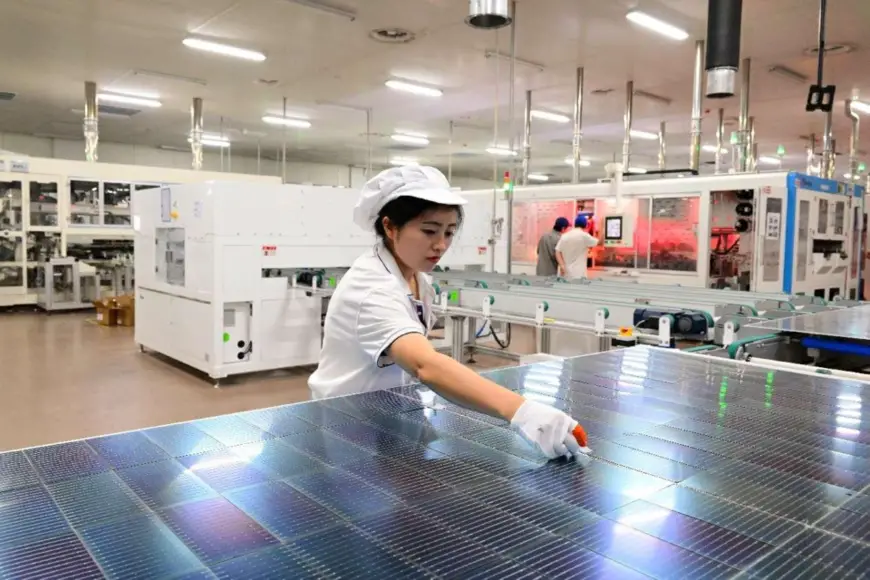 A woman works in a workshop of new energy company Ronma Solar in Jinhua, east China's Zhejiang province. (Photo by Shi Bufa/People's Daily Online)