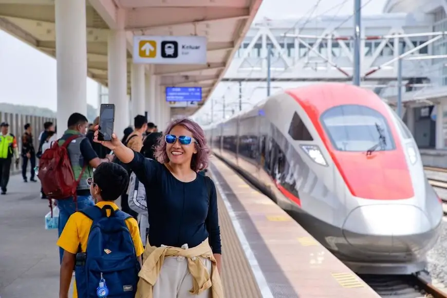 A passenger takes selfie photos with a high-speed electrical multiple unit (EMU) train on a platform of Padalarang Station along the Jakarta-Bandung High-Speed Railway (HSR) in Padalarang, Indonesia, Oct. 17, 2024. (Xinhua/Xu Qin)