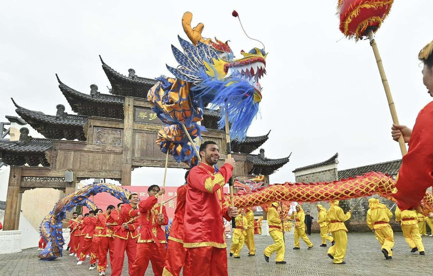 International students from Nanchang University enjoy dragon dance during the Spring Festival in Wenchangli historical area, Fuzhou, east China's Jiangxi province, February 13, 2024. (Photo by Li Jie/People's Daily Online)