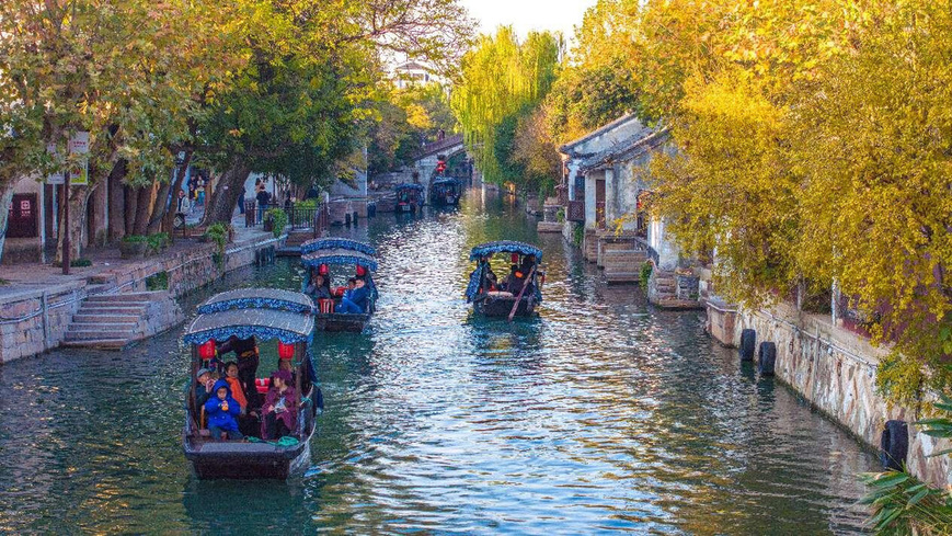 Photo taken on Dec. 8, 2024, shows tourists taking a boat on the river in Nanxun ancient town in Huzhou, east China's Zhejiang province. (Photo by Tu Xudong/People's Daily Online)