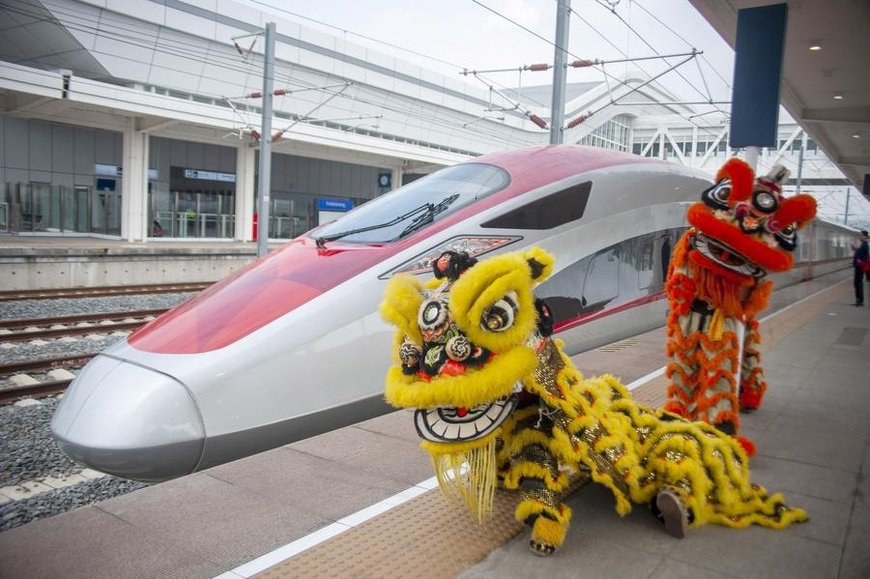 Lion dance performers pose for photos with a high-speed electrical multiple unit (EMU) train on the platform at the Jakarta-Bandung High-Speed Railway's Padalarang Station in Padalarang, Indonesia, Feb. 10, 2024. (Photo by Septianjar Muharam/Xinhua)