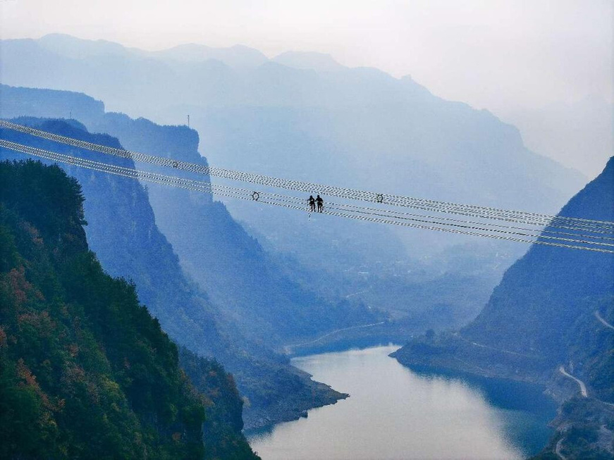 Photo shows the construction of the ±800 kV ultra-high-voltage direct current (UHVDC) transmission project in Wuyaba village, Hongtu township, Enshi, central China's Hubei province, Dec. 19, 2024. (Photo by Zhang Yuanming/People's Daily Online)