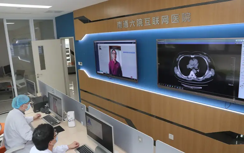 Photo taken on May 8 shows Mao Liping (left), chief physician at the Sixth People’s Hospital of Nantong, inquires about a patient’s physical conditions via a video link. Photo by Xu Congjun/People’s Daily Online