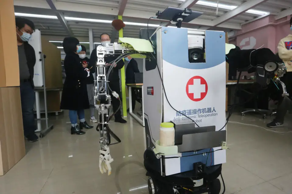 An anti-epidemic teleoperation robot developed by the College of Artificial Intelligence under China's Nankai University displays how it works, April 1. The robot can be controlled by mobile phones, and is able to measure temperature, serve as a hospital guide, disinfect, and transfer samples. Besides, it can also inspect the wards with the cameras installed, and help the doctors launch remote consultation. Photo by Liu Dongyue/ People's Daily Online