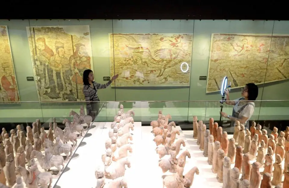Photo taken on May 18, 2020, shows a tour guide at Cizhouyao Museum in Handan, north China's Hebei province, introducing artworks displayed at an exhibition to netizens via live-streaming platform. (Photo by Hao Qunying/People's Daily Online)