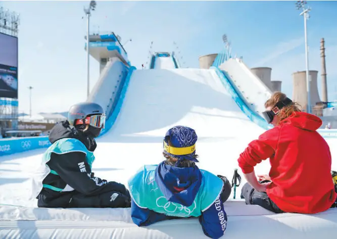 Three Olympic athletes rest after freeski big air training at Big Air Shougang in Beijing, Feb. 6, 2022. (Photo by Li Ge/People’s Daily)