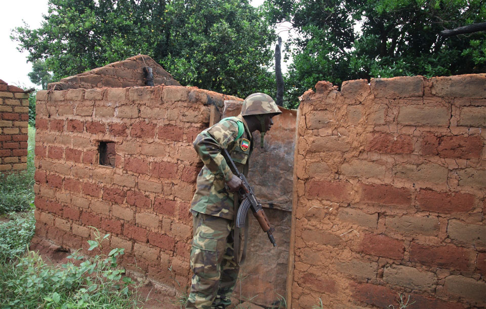 Un Casque bleu africain inspecte une maison abandonnée dans l'un des nombreux villages le long d'une route au sud de Bossangoa, en République centrafricaine. Photo: IRIN/Hannah McNeish