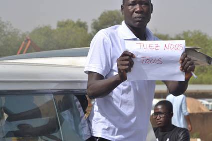 Un jeune homme brandit un message lors de la marche d'aujourd'hui à N'Djamena. Crédit photo : L'Union