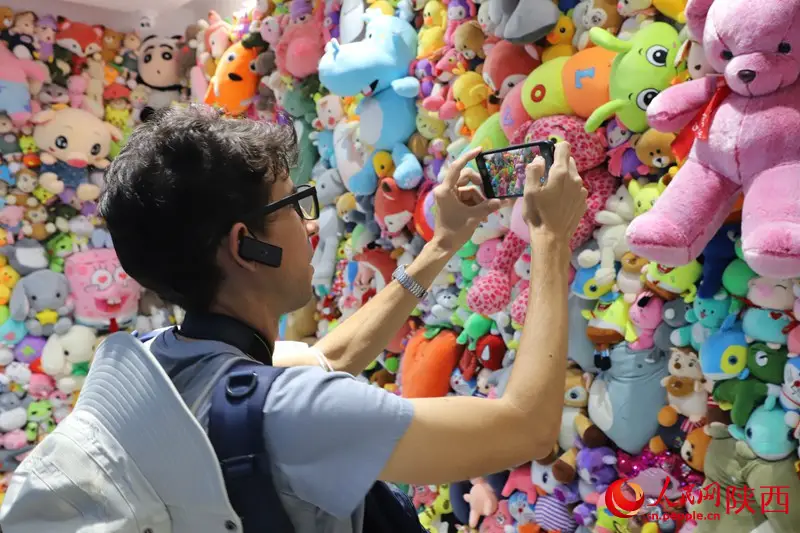 A foreign journalist takes photos in a plush toy factory in Ankang, northwest China's Shaanxi province. (Photo by Li Zhiqiang)