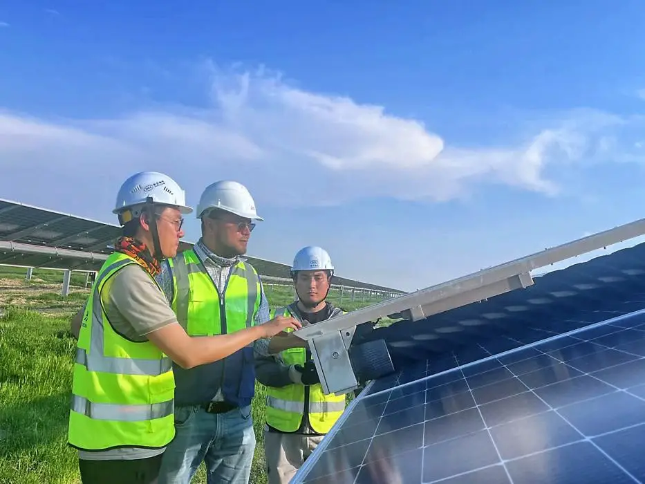 At the 220 MWac Samarkand solar PV plant in Uzbekistan, a Chinese engineer is training local maintenance staff on how to use an AI-enabled cleaning robot. (Photo by Chang Jin)