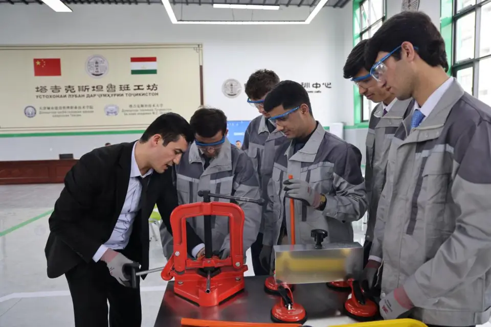 A Tajik professor instructs students to operate devices donated by China at the Luban Workshop in Tajikistan. (Photo by Yan Huan/People's Daily)