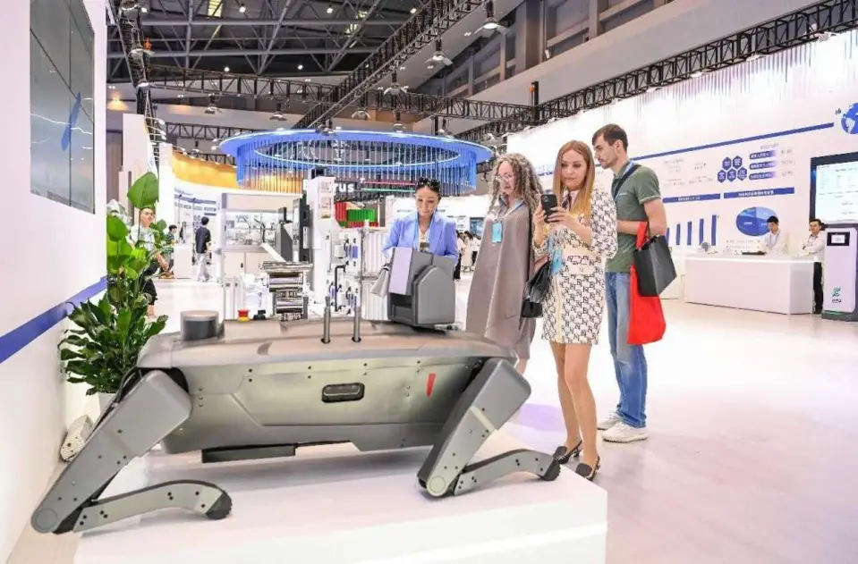 The 6th Western China International Fair for Investment and Trade kicked off on May 23, 2024 in southwest China's Chongqing municipality. Photo shows foreign visitors looking at an explosion-proof four-legged robot at an exhibition stand. (Photo by Wang Jiaxi/People's Daily Online)