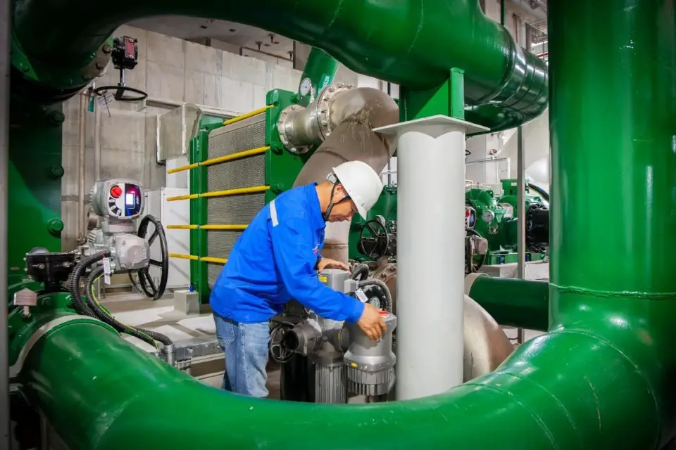 A staff member is adjusting the valves of the closed-loop cooling water system for the compressor at a compressed air energy storage station. (Photo by Ding Xiaowei)