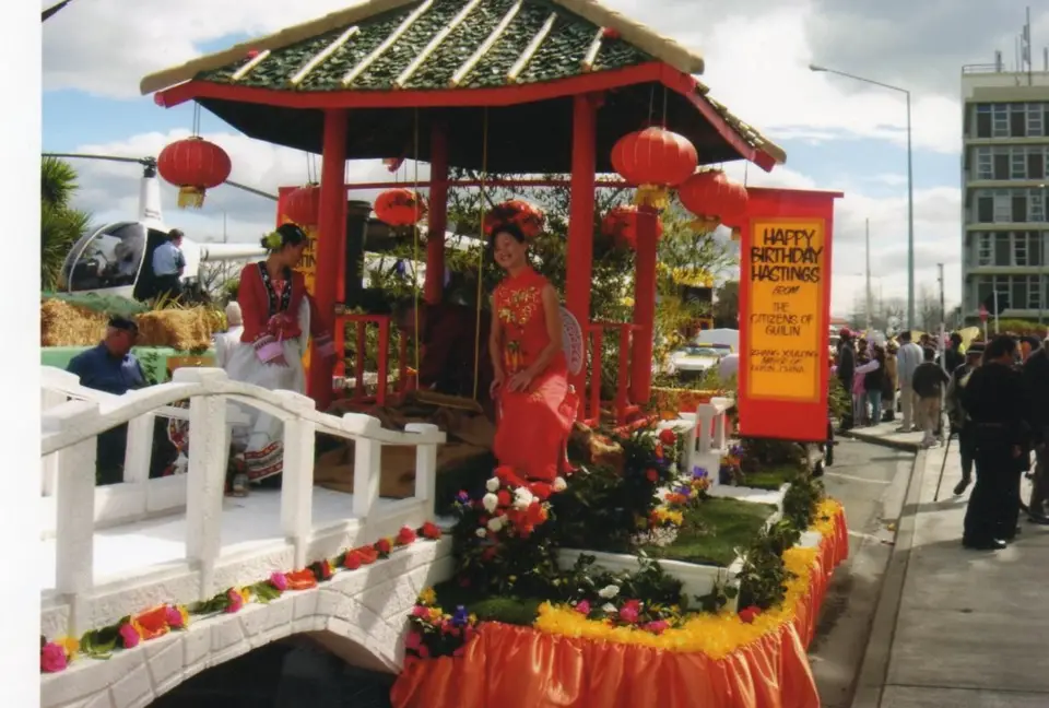 Two girls from Guilin, South China's Guangxi Zhuang Autonomous Region, ride a float in Hastings, New Zealand, 2005. (Photo: Kevin Watkins)