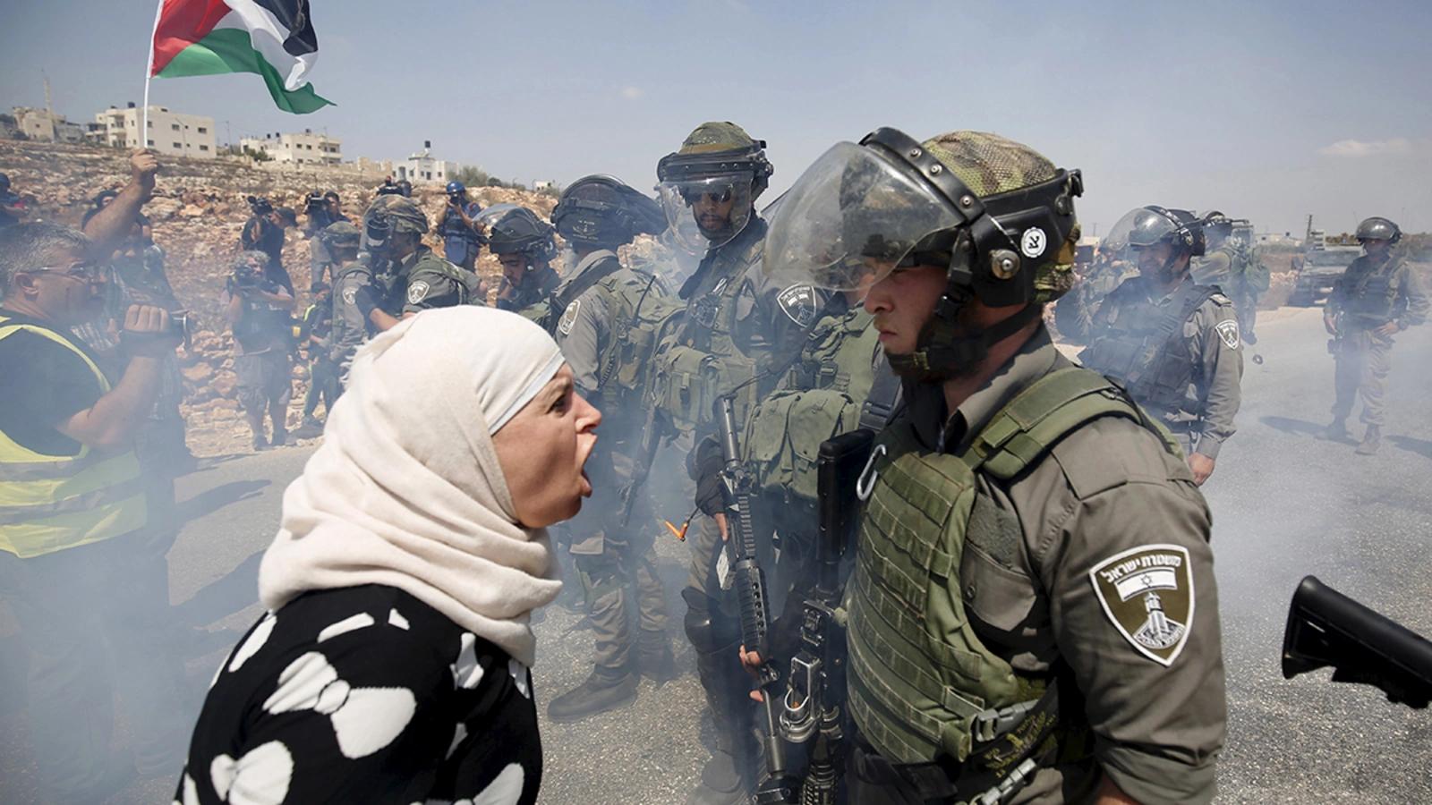 Une Palestinienne se dispute avec un garde-frontière israélien en Cisjordanie. Photo : Mohamad Torokman/Reuters