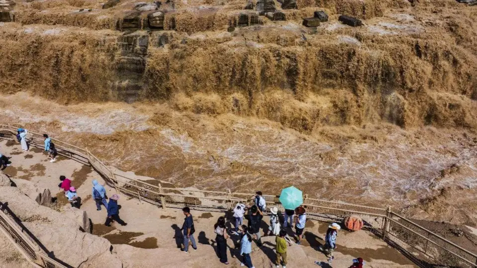 Tourists visit the Hukou Waterfall on the Yellow River in Yichuan county, Yan'an, northwest China's Shaanxi province. (Photo by Zha Zhaoyang/People's Daily Online)