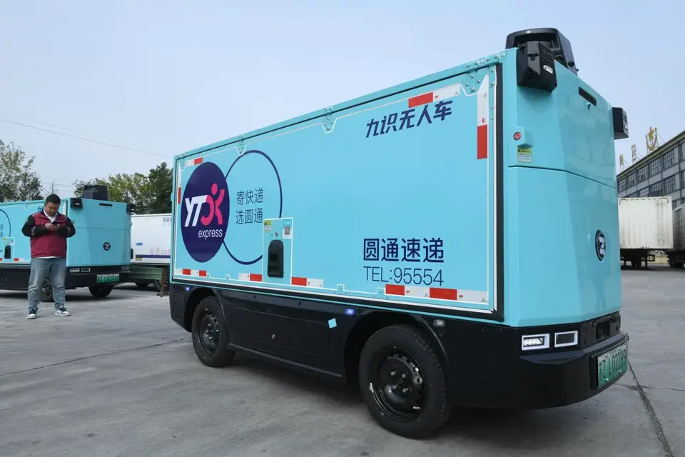 An employee of the Fuyang branch of YTO Express debugs an autonomous delivery vehicle in a logistics park in Fuyang, east China's Anhui province, Nov. 4, 2024. (Photo by Wang Biao/People's Daily Online)