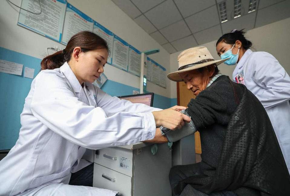 A doctor from Xiangyang, central China's Hubei province, tests blood pressure for a local resident in Qonggyai county of Shannan, southwest China's Xizang autonomous region, Aug. 9, 2024. (Photo by Yang Dong/People's Daily Online)