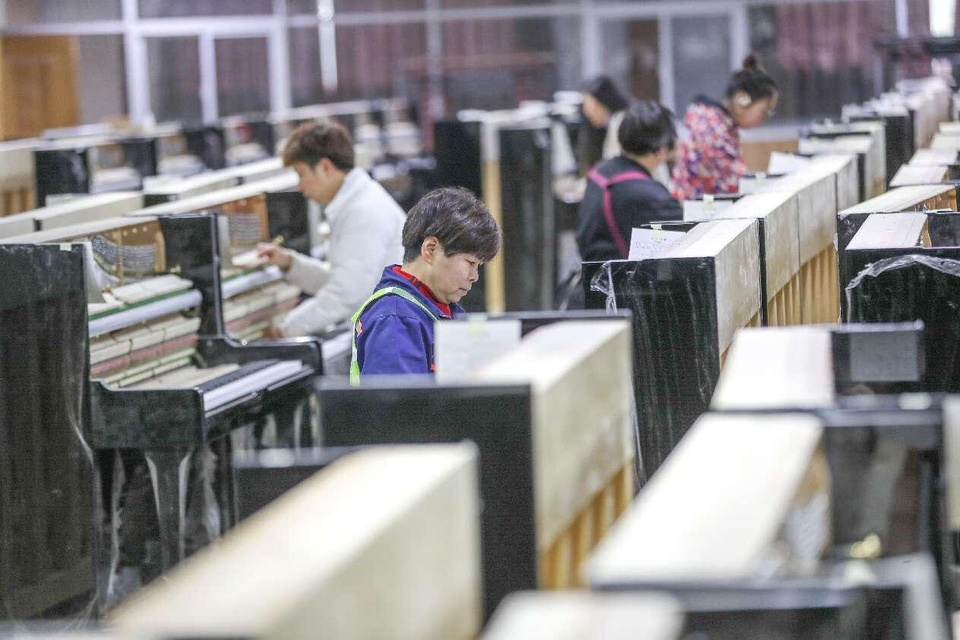 Workers assemble pianos on the production line of Zhejiang Yueyun Piano Co., Luoshe town of Deqing county, Huzhou, east China's Zhejiang province. (Photo by Wang Shucheng/People's Daily Online)