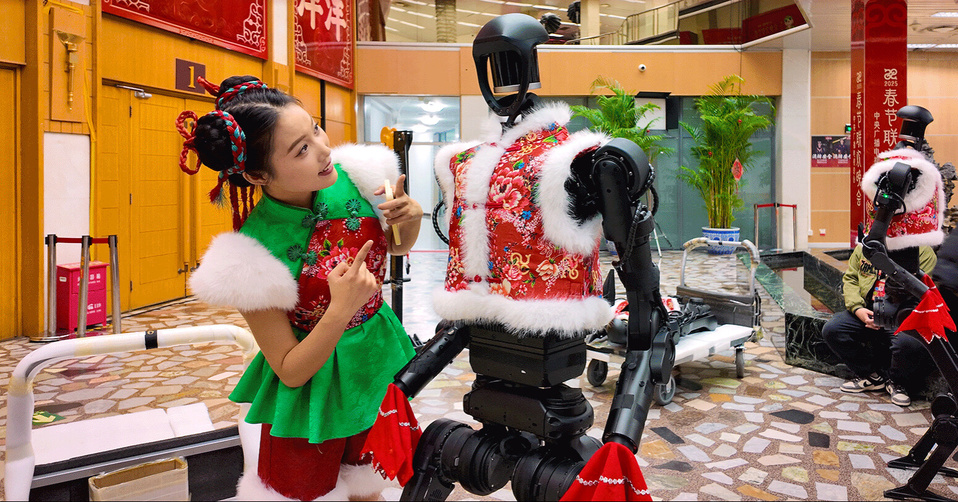 A performer interacts with an H1 humanoid robot developed by Unitree at the backstage of 2025 Spring Festival Gala. (Photo from the official website of Unitree)