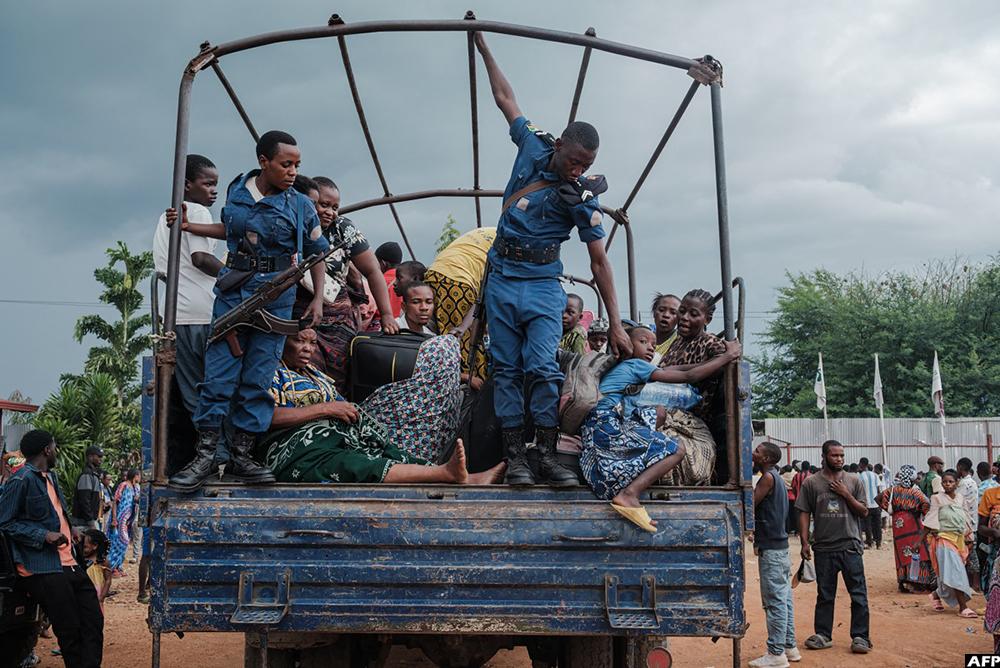 Des policiers burundais aident les réfugiés congolais déplacés par les affrontements en cours dans l'est de la République démocratique du Congo, à descendre d'un camion à leur arrivée au camp de transit de réfugiés de Gihanga, à Gihanga, le 17 février 2025. Photo : AFP